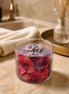 Love Spell Candle with purple wax and floral decorations, set in a stylish bathroom ambiance.