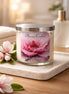 Clear glass jar candle with silver lid and Phoenix Crafted Magnolia label, white wax on a marble tray with pink magnolia blossoms.