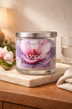 Magnolia Candle in a glass jar with a floral design, placed on a marble surface, perfect for creating a soothing atmosphere.