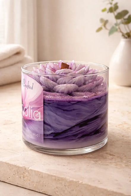 Magnolia Candle in a glass jar featuring a floral design with purple hues and elegant textures.