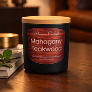 Black jar candle with a light wood lid and red wood-grain label reading 