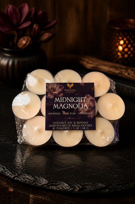 Midnight Magnolia tealights in clear packaging around a Midnight Magnolia product card on a dark stone surface.