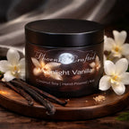 Moonlight Vanilla Candle in a black jar with vanilla pods and flowers, hand-poured coconut soy blend for a cozy fragrance.