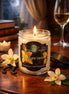Lit Moonlight Vanilla candle in a clear glass jar with vanilla beans, white flowers, and a glass of wine.