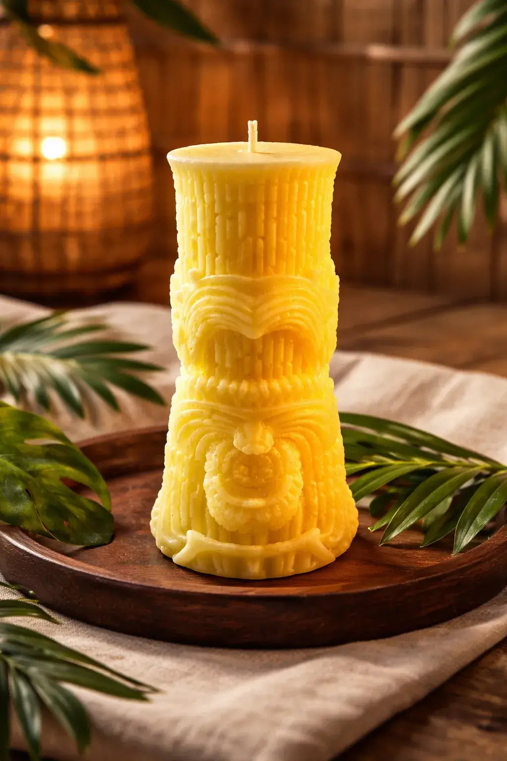 Decorative Naked Berry Candles in a vibrant yellow design on a wooden tray with tropical foliage.