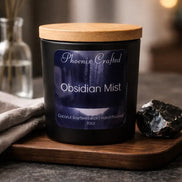 Obsidian Mist Candle displayed on a wooden tray with a raw obsidian stone beside it, featuring a minimalist black jar.