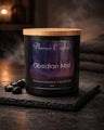 Obsidian Mist Candle by Phoenix Crafted, hand-poured in coconut-soy and beeswax, sitting on a slate surface.
