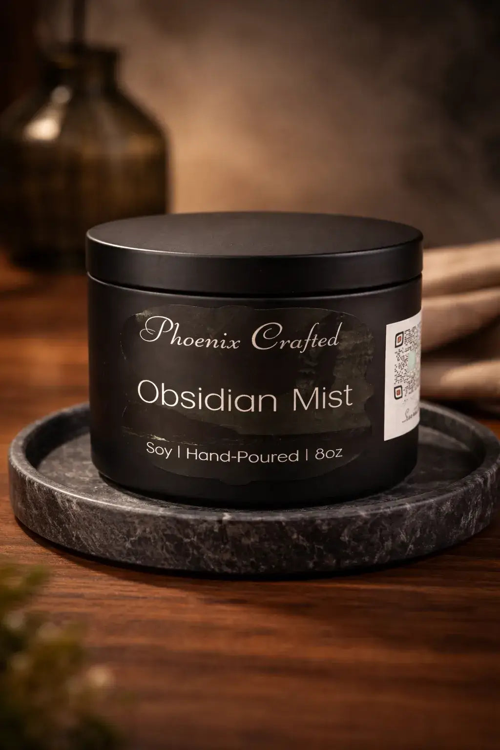 Obsidian Mist Candle in matte black container on marble tray, showcasing hand-poured soy candle craftsmanship.