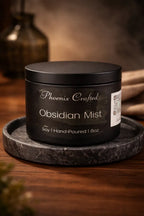 Obsidian Mist Candle in matte black container on marble tray, showcasing hand-poured soy candle craftsmanship.