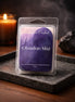 Clear clamshell pack of Obsidian Mist wax melts with a purple watercolor label reading "Phoenix Crafted" on a dark stone tray.