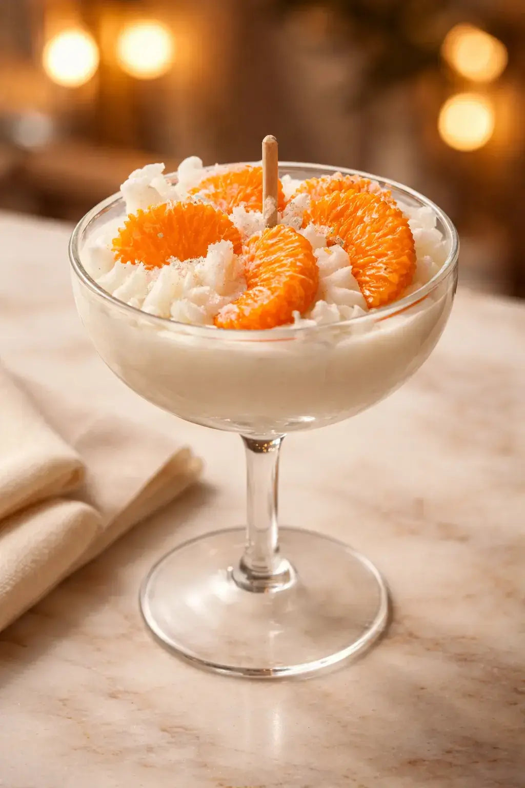 Orange Cream Candle in a glass dish topped with whipped cream and orange slices.
