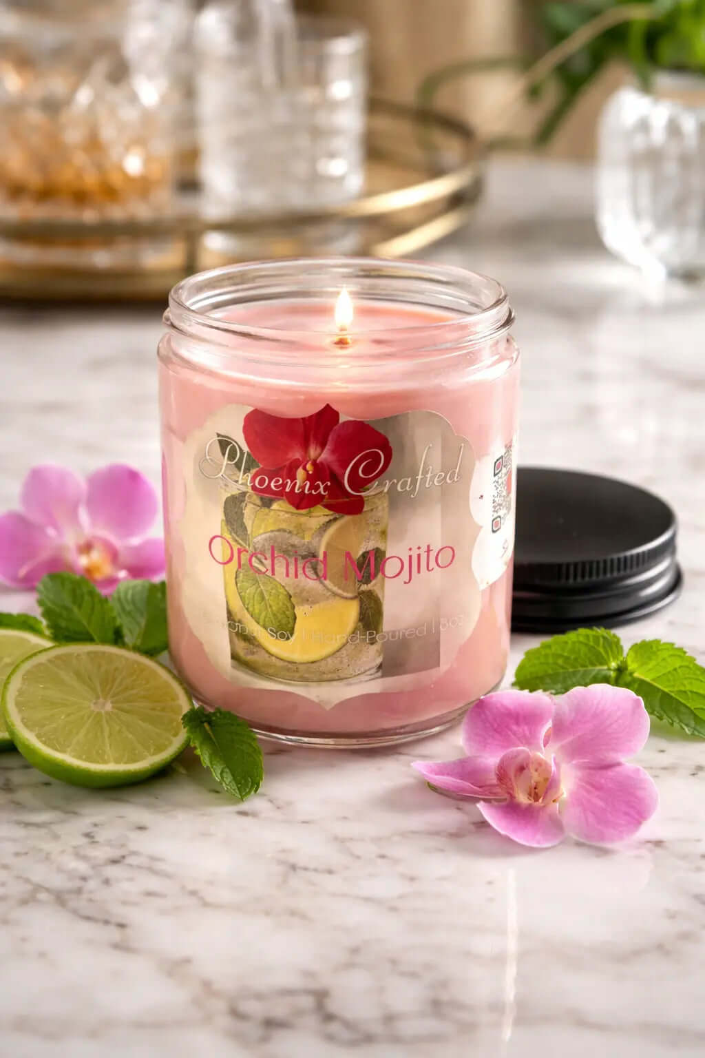 Orchid Mojito Candle in a clear jar, featuring fresh mint, lime, and a pink orchid on a marble surface.