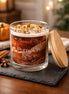 Clear glass jar candle with white wax and crumb-like topping bearing a label that reads Phoenix Crafted Pumpkin Spice.