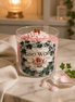 Rose Water & Ivy Candle displayed on a marble surface with rose petals and a soft fabric.