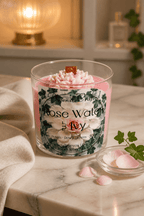 Rose Water & Ivy Candle displayed on a marble surface with rose petals and a soft fabric.