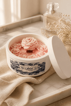 Rose Water & Ivy Candle in a decorative container with floral design, showcasing pink wax roses.