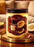 Santal & Coconut Candle in a glass jar with natural coconut and cinnamon sticks on a wooden table.
