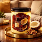 Santal & Coconut Candle in a glass jar with natural coconut and cinnamon sticks on a wooden table.