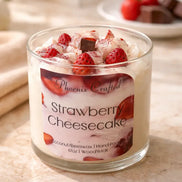 Strawberry Cheesecake Candle in a glass jar with fresh strawberries and chocolate pieces.