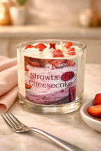 Strawberry Cheesecake Candle in a glass jar with strawberries and whipped cream on top, perfect for cozy atmospheres.