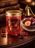 Sugar Plum Candle in a glass jar with a decorative label, set on a wooden table with plums and rose petals.