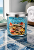 Summer Skinny Dip Candle in a stylish jar with tropical fruit design on a table by the sea.