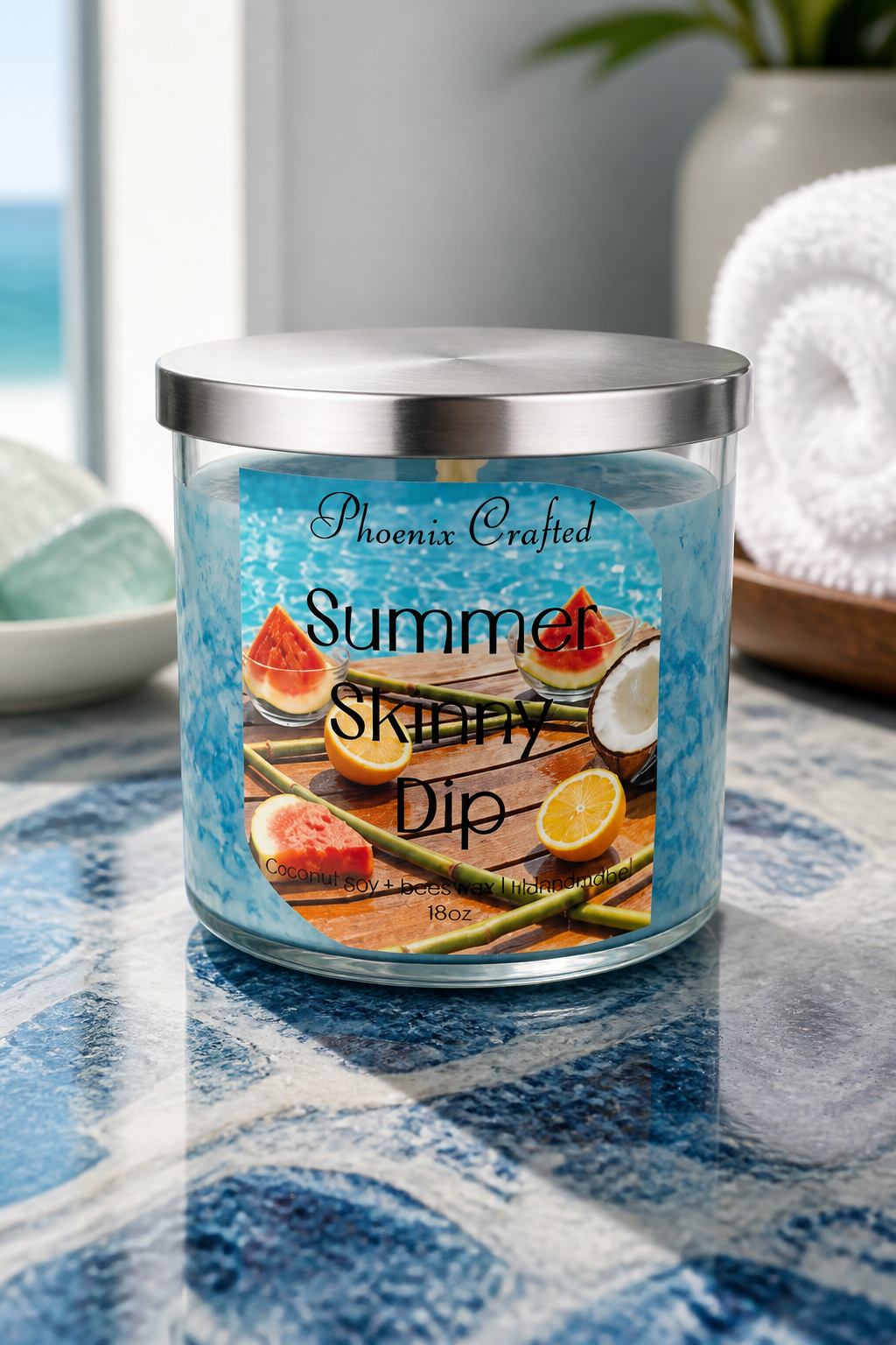 Summer Skinny Dip Candle in a stylish jar with tropical fruit design on a table by the sea.