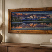 Sunset over Still Waters Diamond Painting displayed in a wooden frame above a console table with decor.