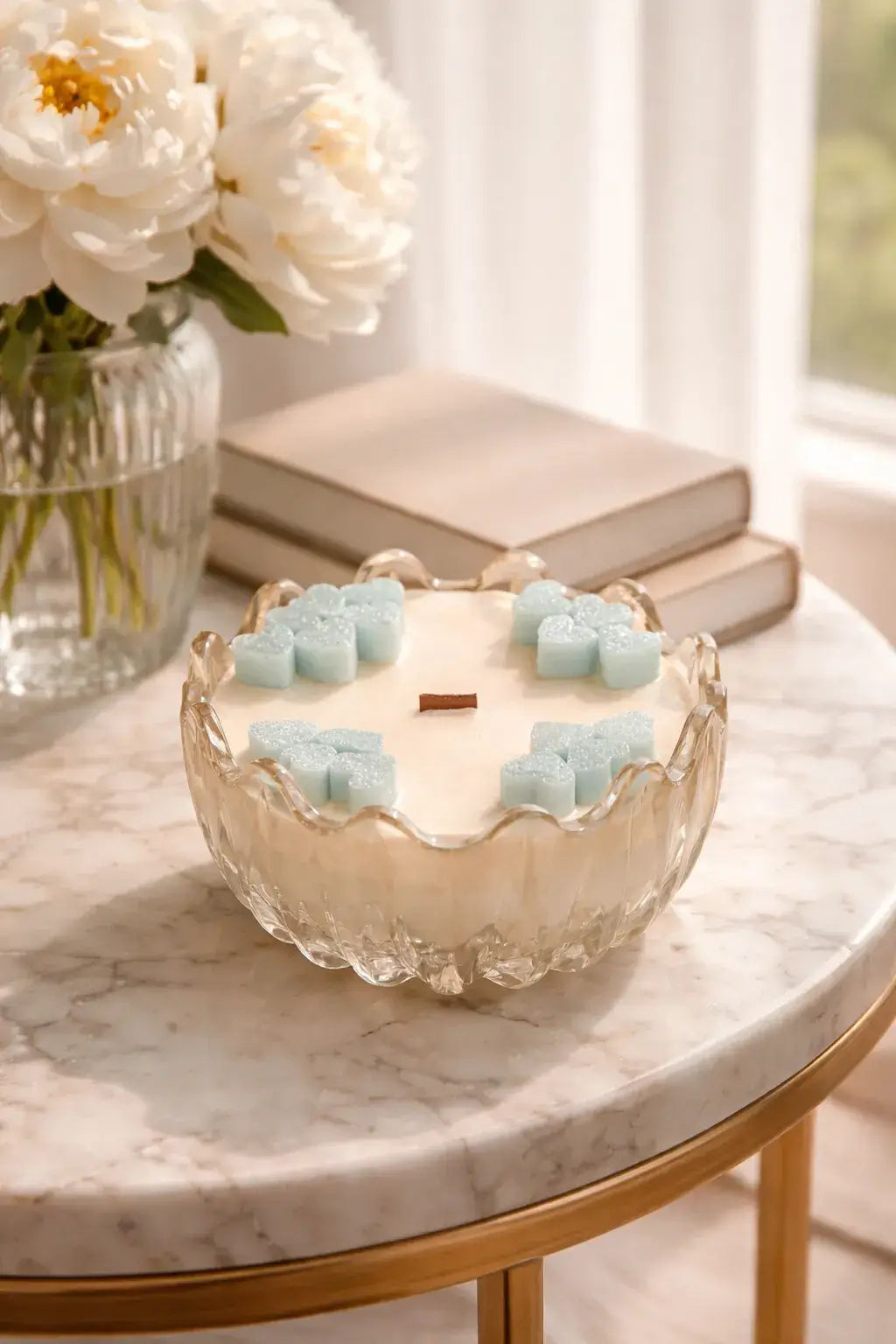 Teak & Mint Renewal Decorative Candles displayed beautifully on a marble table with flowers and books.