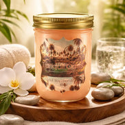 Peach-pink candle in a clear glass mason jar with gold screw lid labeled 