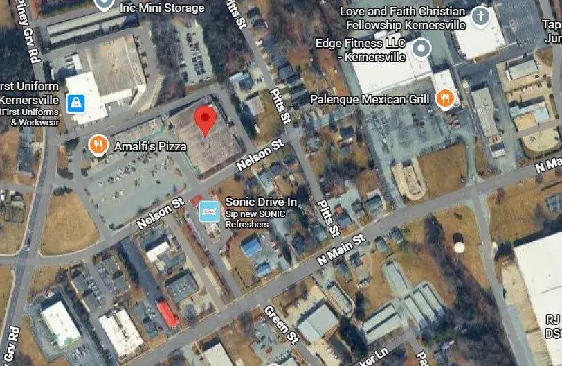 Aerial view of a small town with various businesses and roads.