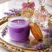 Viva La Juicy Candle on a silver tray surrounded by lavender, with decorative perfume bottles in the background.