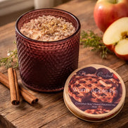 Warm Apple Pie Decorative Candles in a stylish amber jar surrounded by cinnamon sticks and fresh apples.