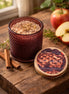 Warm Apple Pie Decorative Candles in a stylish amber jar surrounded by cinnamon sticks and fresh apples.