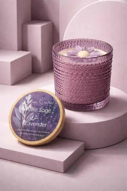 Lavender-hued textured glass candle with cream wax and a purple flower topper.