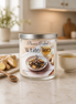 White Tea & Ginger Candle in a glass jar on a kitchen counter with ginger pieces and a cup of tea.