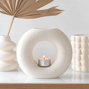 Cream Speckle Bubble Tealight Wax Warmer surrounded by decorative vases and foliage on a minimalist display.