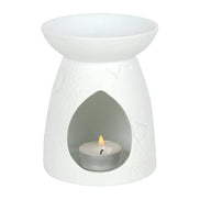 White matte ceramic tealight warmer with conical base and teardrop front opening revealing a lit aluminum tealight.