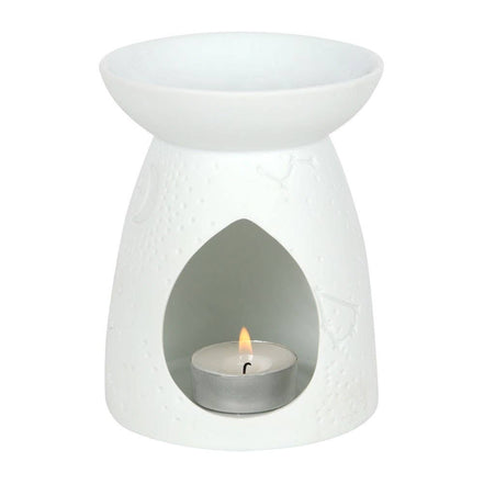 White matte ceramic tealight warmer with conical base and teardrop front opening revealing a lit aluminum tealight.