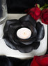 Black rose tealight candle holder with a lit tealight, surrounded by red roses and black decor.