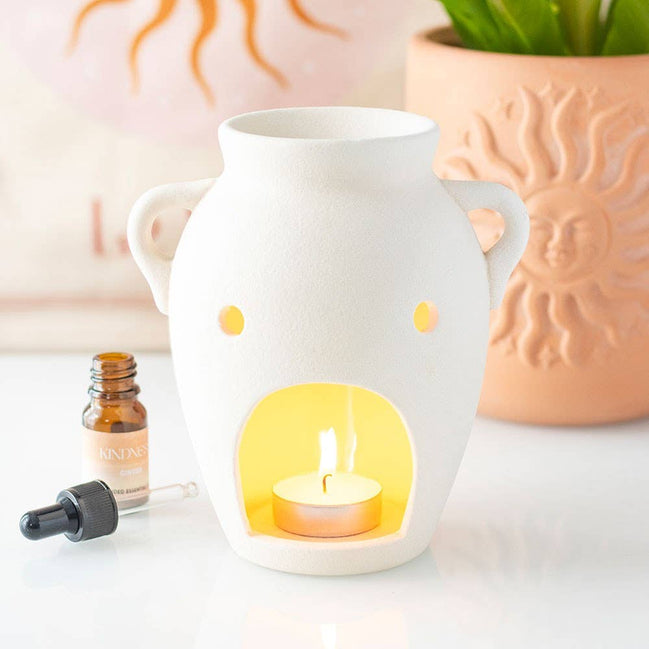 Vase shaped oil burner and wax warmer with a textured finish and soft flickering glow, enhancing home relaxation.