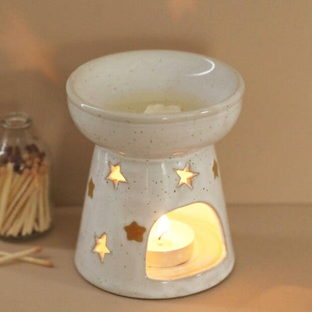 Speckled off-white ceramic wax melt warmer with shallow top bowl holding melted wax.