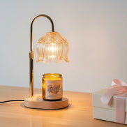 Lamp warmer for candles with elegant design, featuring a glass shade and a lit jar candle on a wooden base.