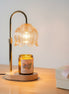 Lamp warmer for candles with elegant design, featuring a glass shade and a lit jar candle on a wooden base.