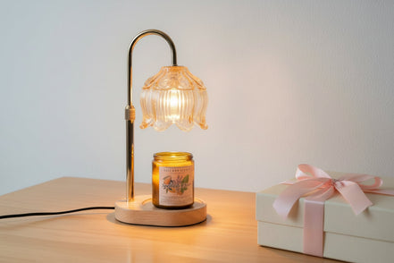 Lamp warmer for candles with elegant design, featuring a glass shade and a lit jar candle on a wooden base.