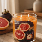 Grapefruit & Mangosteen candle with grapefruit slices, showcasing its vibrant scent and warm ambiance.