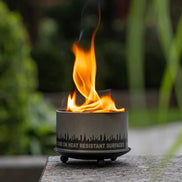 Side view of the black metal trivet and candle holder.