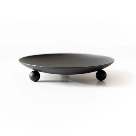 Black wrought-iron trivet and candle holder displayed as a compact tabletop accessory.