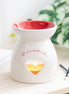 Valentine's Day Heart Oil Burner and Wax Warmer with heart cut out and 'All you need is love' text.