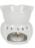 White ceramic owl-shaped wax warmer with top bowl, teardrop cutouts and a lit silver tealight in the front cavity on a white background.